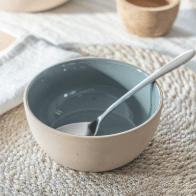 A small, round bowl with a rich blue glaze. The smooth surface reflects light, showcasing its elegant design. Perfect for serving side dishes with a touch of timeless charm.